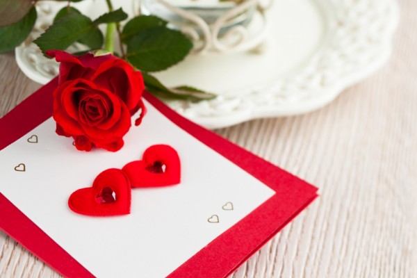 Una rosa y una tarjeta con corazones para el Día de San Valentín