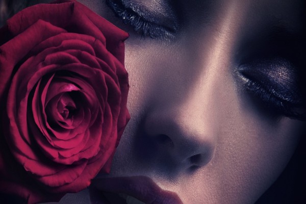 Mujer pensativa junto a una rosa