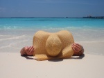 Tomando sol en la playa con un gran sombrero