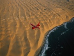 Avión sobrevolando el mar y la playa