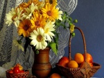Gerberas en un florero y albaricoques en una cesta