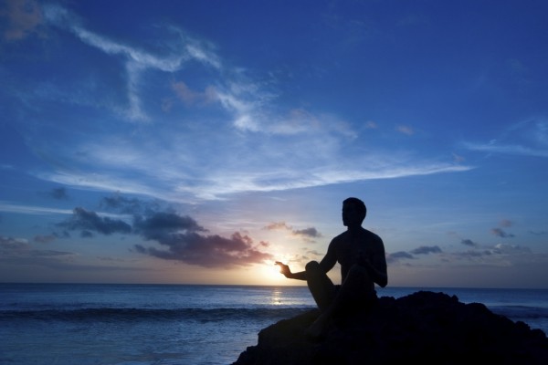 Meditando en una roca junto al mar