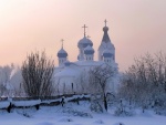 Iglesia, camino y árboles cubiertos con nieve