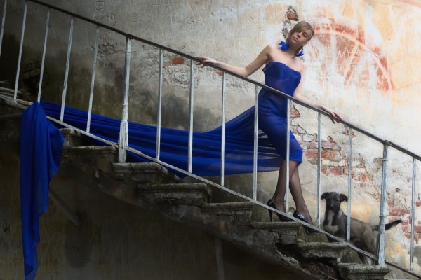 Bella mujer bajando las escaleras, con un vestido azul