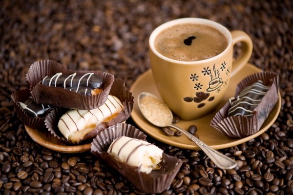 Taza de café acompañado con pasteles de chocolate