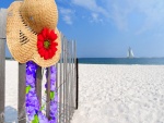 Sombrero y collar de flores en la playa