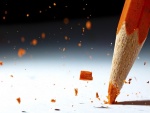 Rompiendo la punta de un lápiz naranja
