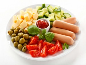 Plato con salchichas, queso, aceitunas y vegetales
