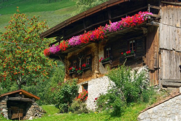 Antigua casa con flores en el balcón