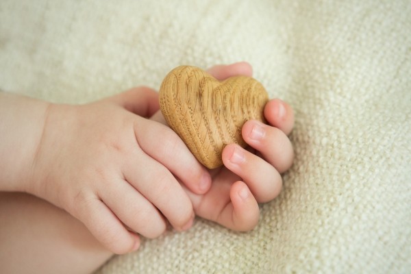 Manos de bebé sosteniendo un corazón