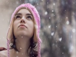 Una joven mirando la nieve caer