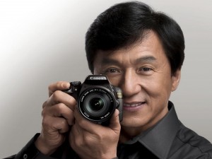 Postal: El actor Jackie Chan con una cámara de fotos
