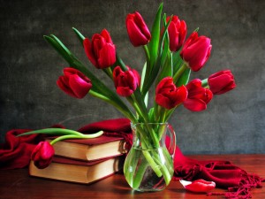 Jarrón con tulipanes junto a unos libros