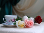Rosas junto a una taza de té