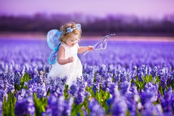 Nena caminando por un campo con flores