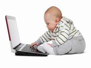 Postal: Un bebé tecleando en un portátil