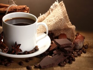 Taza de café acompañado de especias y chocolate