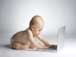 Bebé en pañales jugando con el ordenador