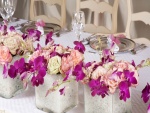 Flores en recipientes de vidrio adornando la mesa