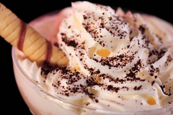 Copa de helado cubierta de nata con cacao