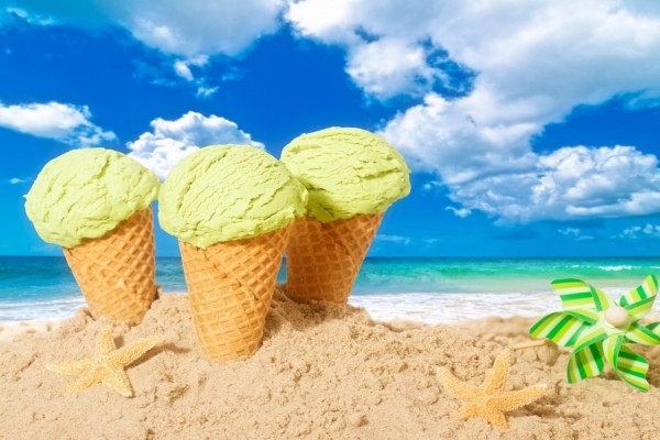 Tres conos con helado en la arena
