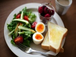 Huevo cocido con ensalada y cerezas para el desayuno