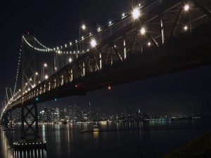 Postal: Un puente iluminado en la noche oscura