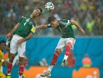 Dos jugadores de la Selección Mexicana en el partido contra Camerún (Mundial 2014)