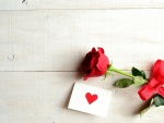 Rosa con cinta roja y una carta de amor