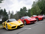 Un Ferrari de color amarillo y dos de color rojo