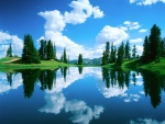 Lago con el reflejo de nubes y pinos