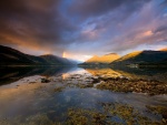 Arco iris entre nubes y montañas de Escocia