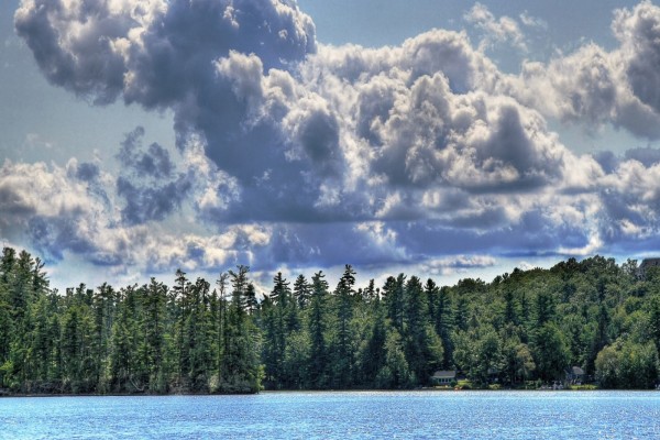 Grandes nubes sobre el lago y los pinos