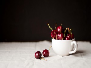 Postal: Una taza con cerezas