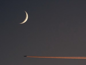 Avión atravesando el cielo bajo la luna