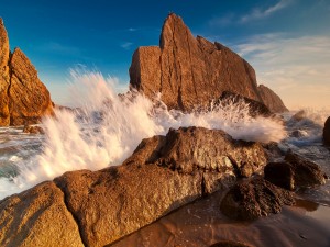 Postal: El agua del mar entre grandes rocas