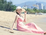 Bella mujer asiática sentada sobre la arena