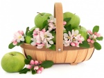 Una cesta con manzanas verdes y aromáticas flores