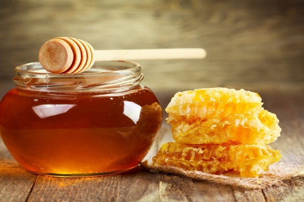 Frasco con miel y panal de abeja