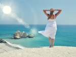 Un mujer contemplando el mar y los rayos del sol