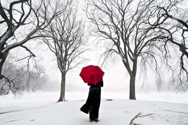 Caminando sobre la nieve con un paraguas rojo