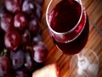 Copa de vino tinto junto a unas uvas negras