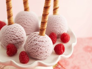 Barquillos sobre bolas de helado de frambuesas
