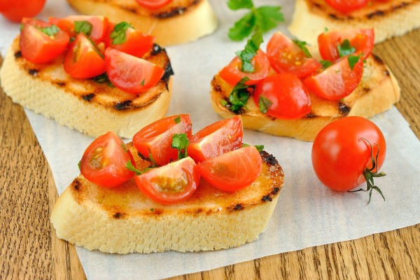 Rebanadas de pan con tomatitos cherry y aceite de oliva