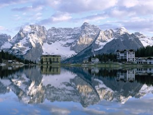 Postal: Las montañas y edificios reflejados en el lago