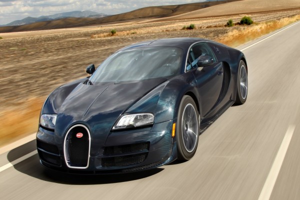 Bugatti Veyron de color oscuro circulando por una carretera