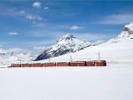 Un tren rojo atravesando parajes cubiertos de nieve