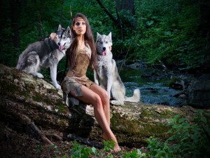 Hermosa mujer con dos perros junto a un río