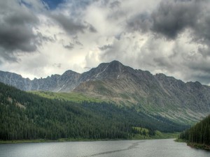 Postal: Nubes grises sobre el lago y las montañas