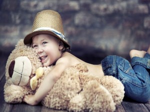 Sonriente bebé abrazado a un oso de peluche